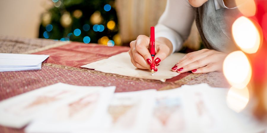 A lady writing on paper using red pen.