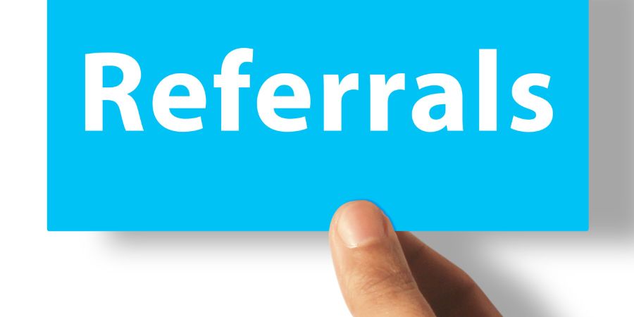 Holding blue paper with referrals note.