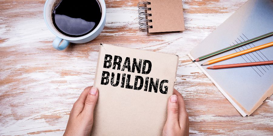 Brown notebook and coffee on wooden table.
